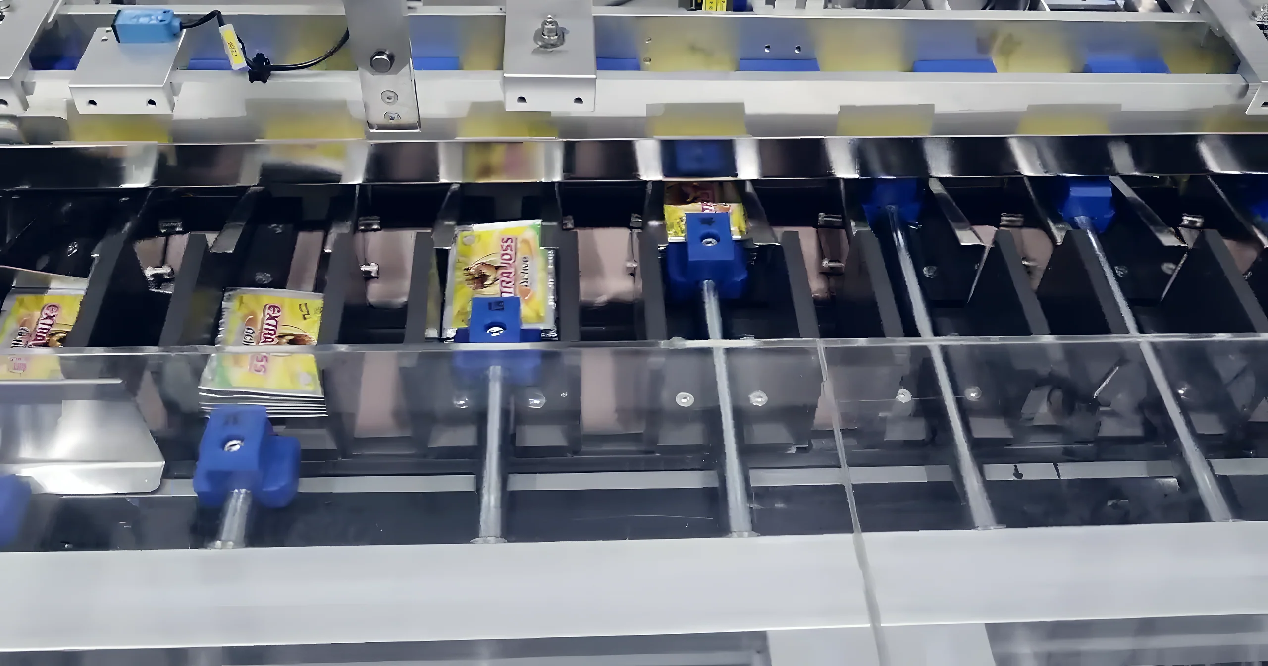 버킷마다 제품이 한 개씩 놓인 실제 카토너 버킷 컨베이어